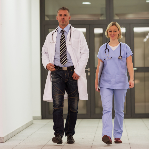 Imagen de un médico y un enfermero caminando por un pasillo de un centro sanitario